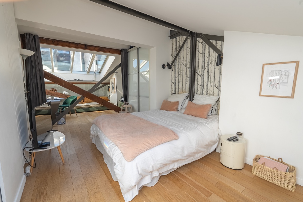 Ydd9wevitwuKiVBSXESfWfxzRNGTTloNQiRuKUPB.jpg chambre appartement Eiffel avec lit, espace bureau sous baie vitrée