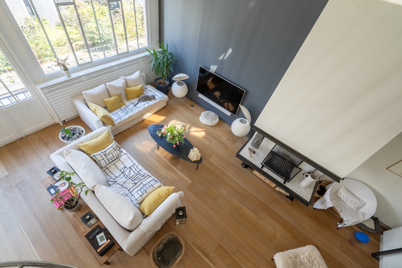 e3iogWrRslWUd6N8VjfTr2FPHlklfreDrpVZiQb2.jpg salon appartement Eiffel  avec canapé et cheminée vu de haut